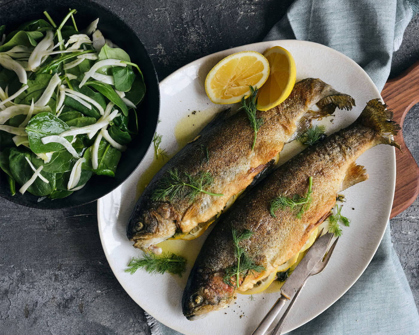 Stuffed Trout with spinach and fennel salad plated on counter