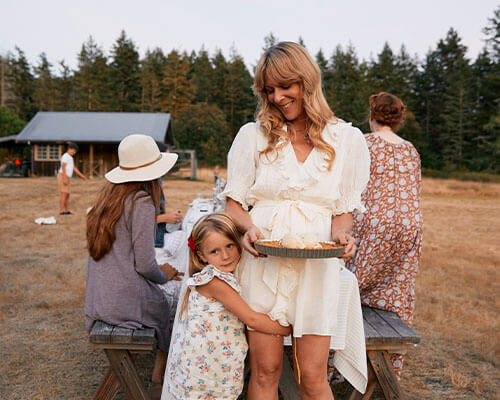 Audra and a little girl hugging her leg