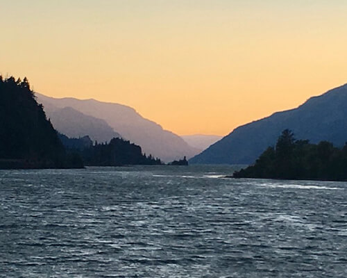 sunset on a lake with mountains